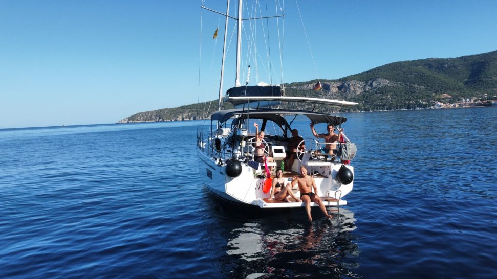 Die Crew Die Crew winkt vom Boot in die Drohnenkamera.